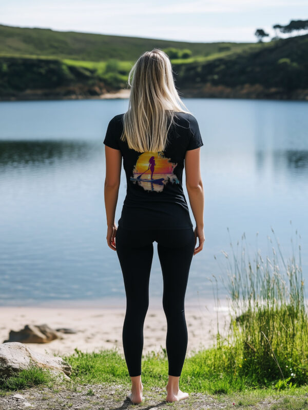 Women's Black regular fit T-Shirt made from 100% Organic Cotton with a large image printed on the back of a female paddle boarder set against a setting sun. The tee is finished off with Vibrant Orange SUP Funk logo on the front left chest.