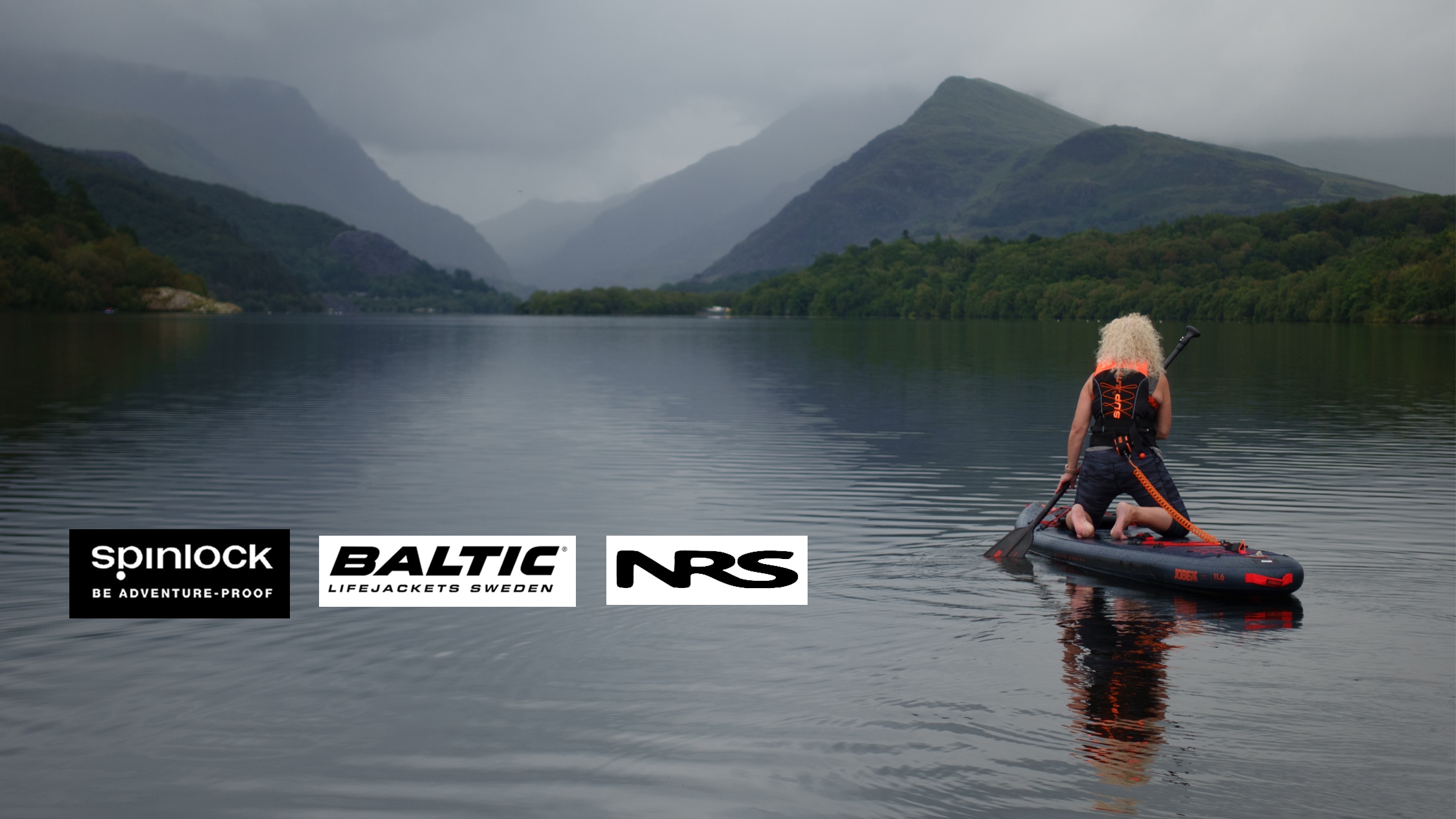 Woman paddle boarder on picaresque lake wearing a buoyancy aid and overlayed Brand Logos