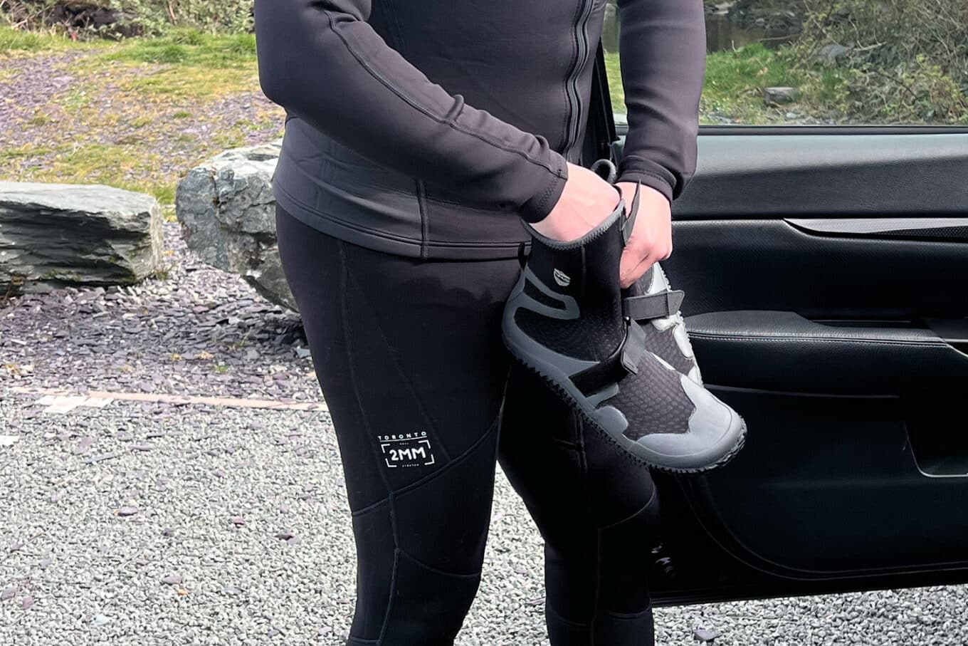 Nigel Waters putting on a NRS Paddle Wetshoe - Late Autumn