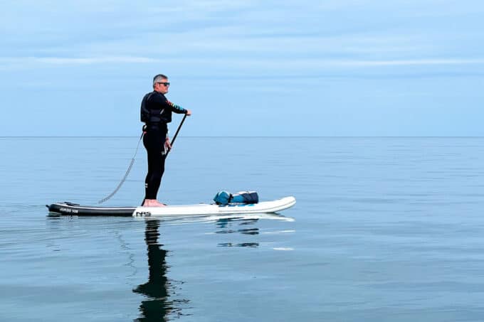 Nigel paddleboarding an NRS inflatable paddle board on calm water