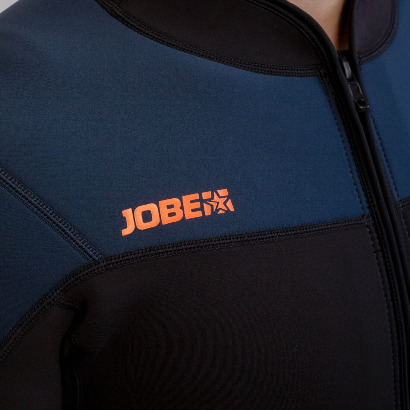 Close-up of the Jobe chest logo, stretch neoprene panels and flatlock seams